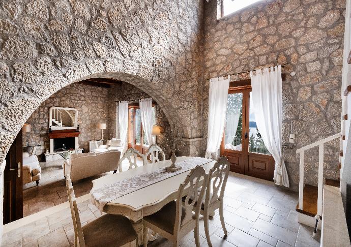 Stone archway framing a formal dining table and cozy living area . - Villa Galatia . (Photo Gallery) }}