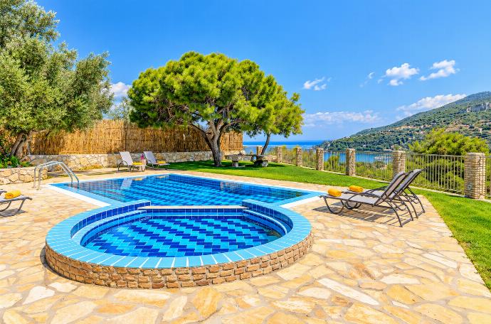 Private swimming pool with rounded steps, sun loungers, mature trees, and beautiful countryside views.