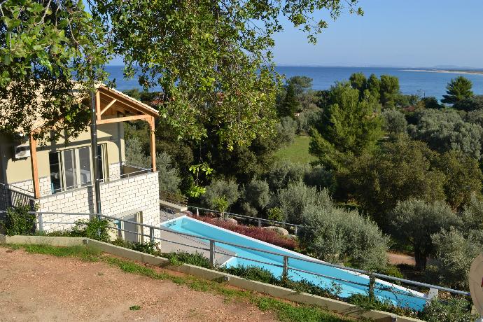 An elevated view showcases a multi-level hillside villa illuminated at dusk, featuring a private swimming pool, terrace spaces, and surrounding green forest. . - Villa Oleana . (Galerie de photos) }}