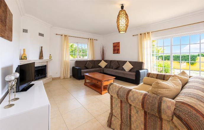 Bright living room with comfortable sofas, modern lighting, tiled flooring, and plenty of natural light.
