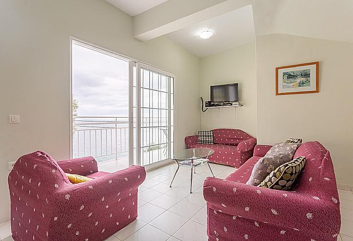 Open-plan living room with sofas, dining area, kitchen, WiFi Internet, TV, DVD player, and terrace access with sea views . - Villa Thalassa . (Fotogalerie) }}