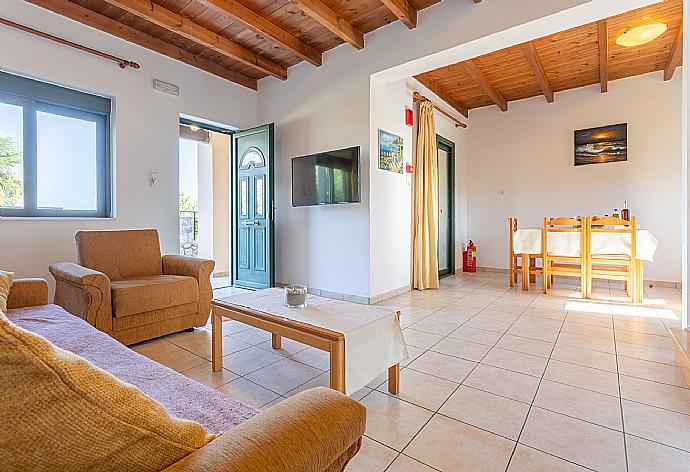 Open-plan living room with sofas, dining area, kitchen, A/C, WiFi internet, satellite TV, DVD player, and terrace access . - Spiros Beach Villa . (Fotogalerie) }}