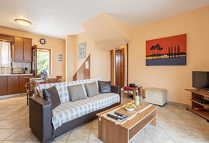 Open-plan living room with sofas, dining area, kitchen, ornamental fireplace, A/C, WiFi internet, satellite TV, and sea views . - Villa Yeraki . (Photo Gallery) }}