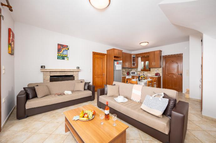 Open-plan living room with sofas, dining area, kitchen, ornamental fireplace, A/C, WiFi internet, and satellite TV . - Villa Yeraki . (Photo Gallery) }}