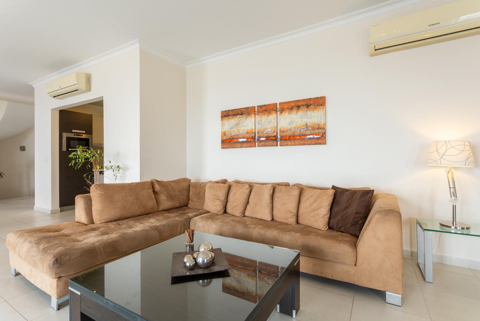 Open-plan living room with sofas, dining area, kitchen, ornamental fireplace, A/C, WiFi internet, satellite TV, and terrace access with sea views