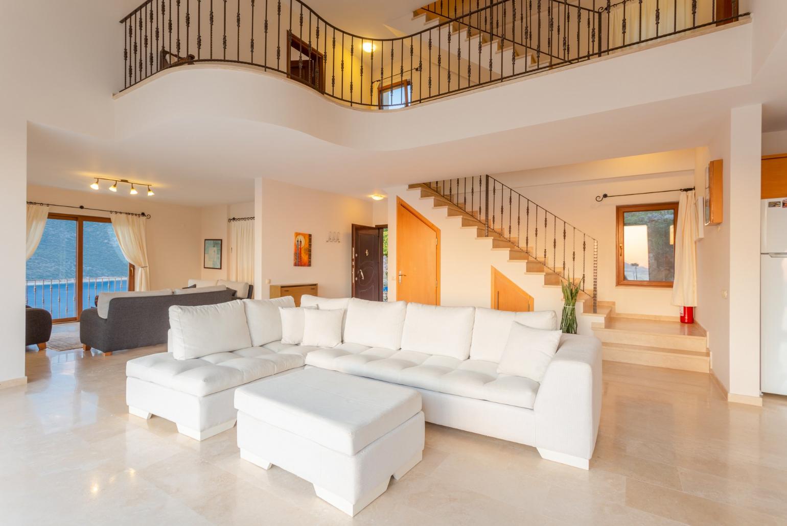 Open-plan living room with sofas, dining area, kitchen, A/C, WiFi internet, satellite TV, DVD player, and terrace access with panoramic sea views