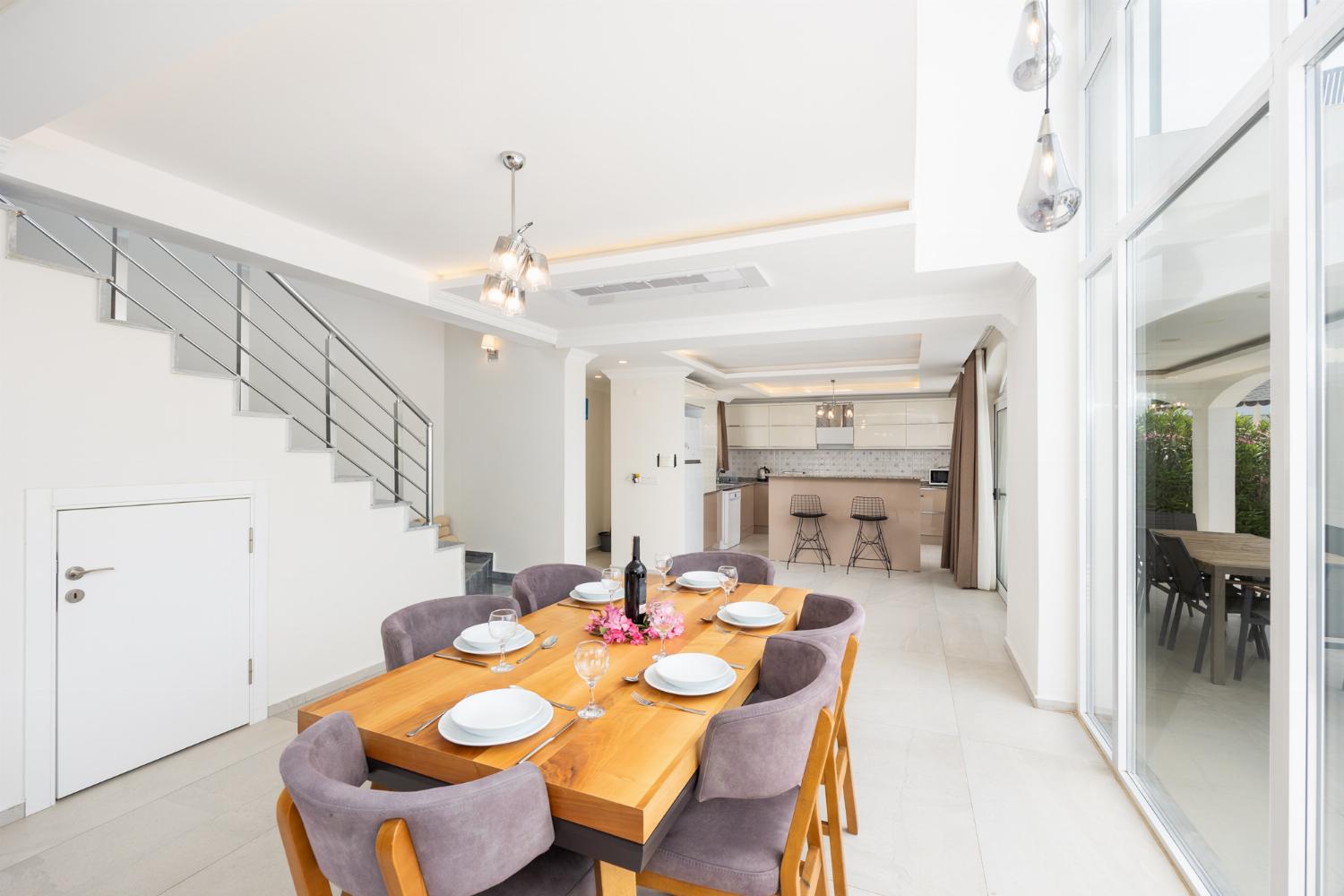 Open-plan living room with sofas, dining area, kitchen, A/C, WiFi internet, and satellite TV