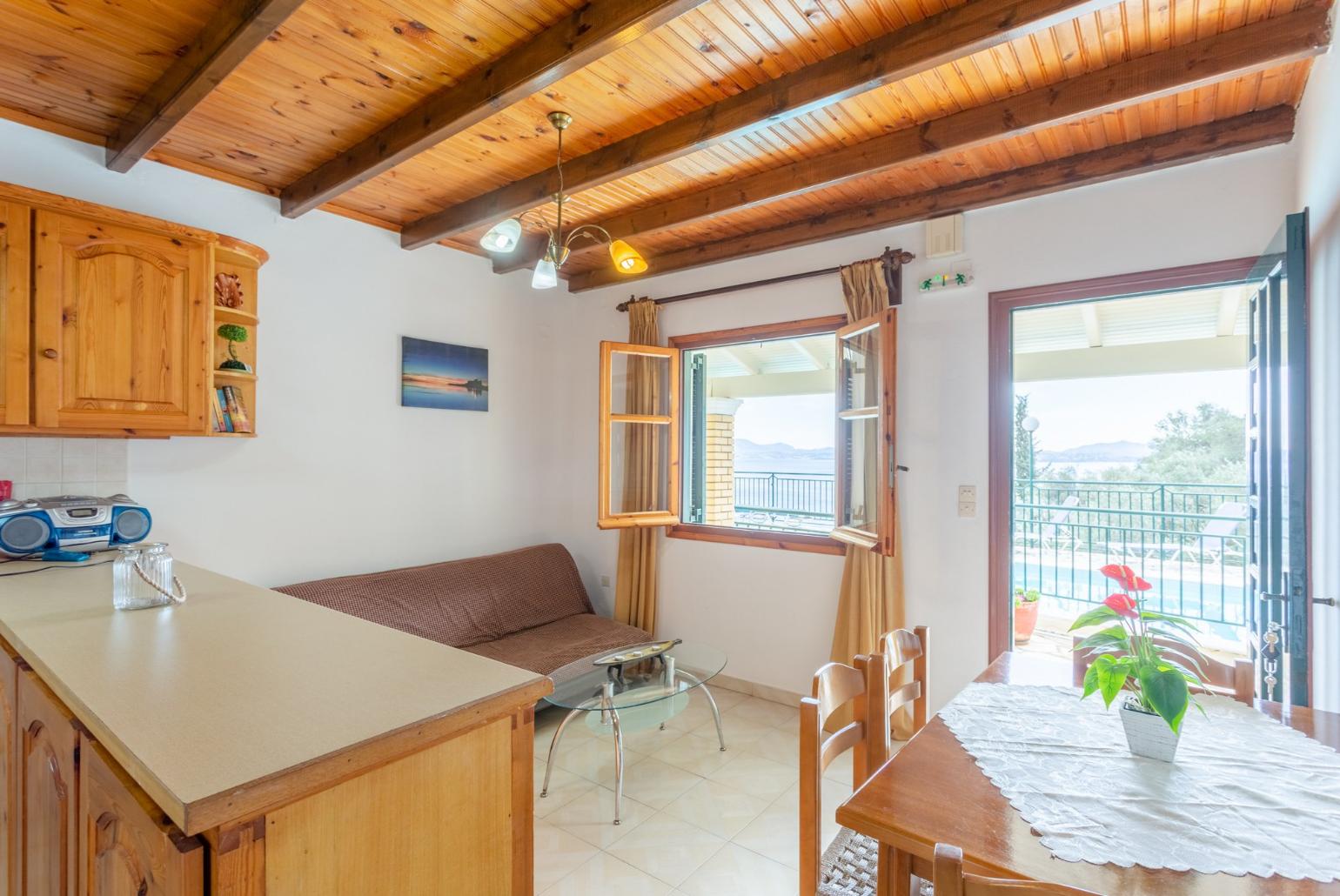 Living room with sofa, dining area, kitchen, and terrace access