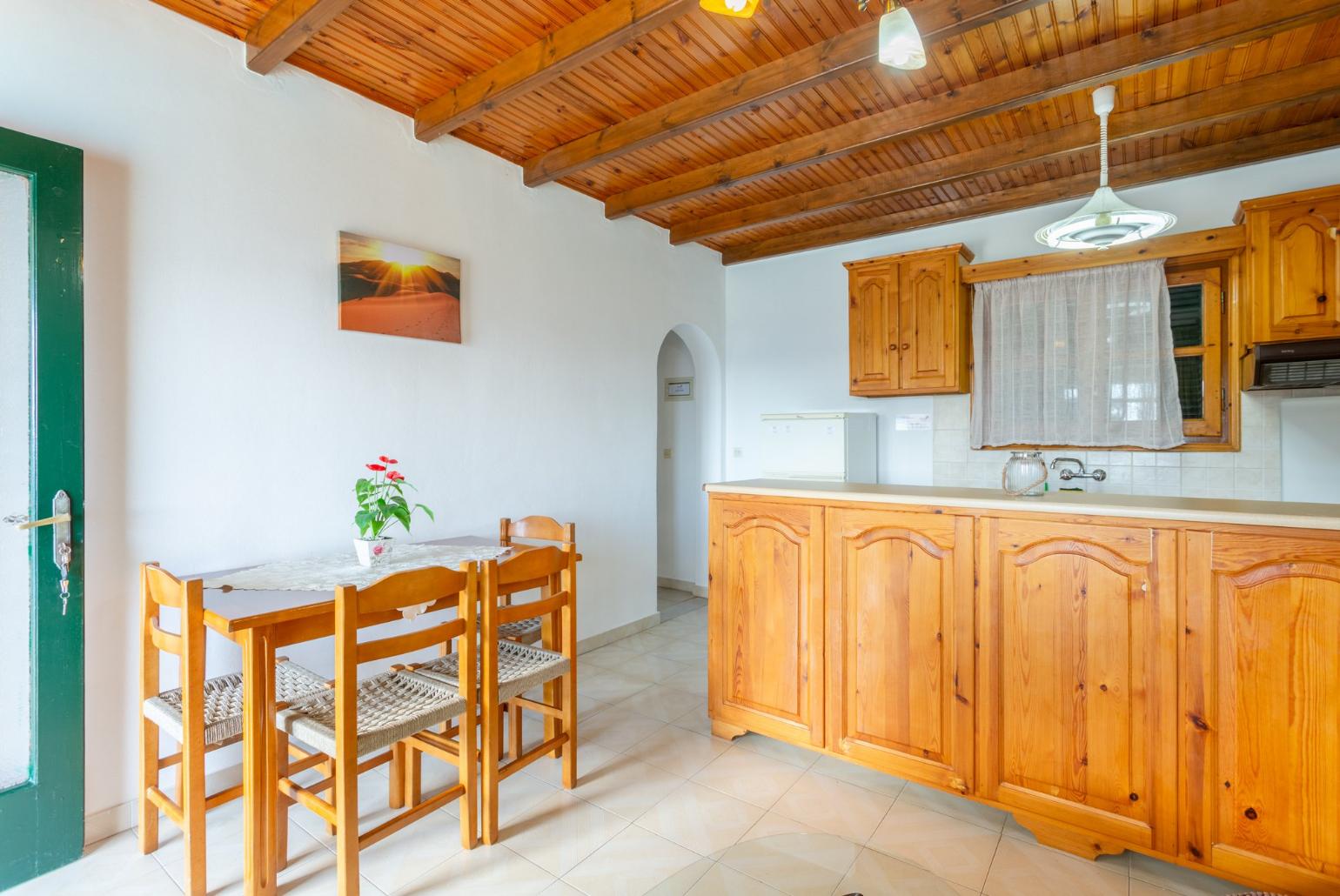 Living room with sofa, dining area, kitchen, and terrace access