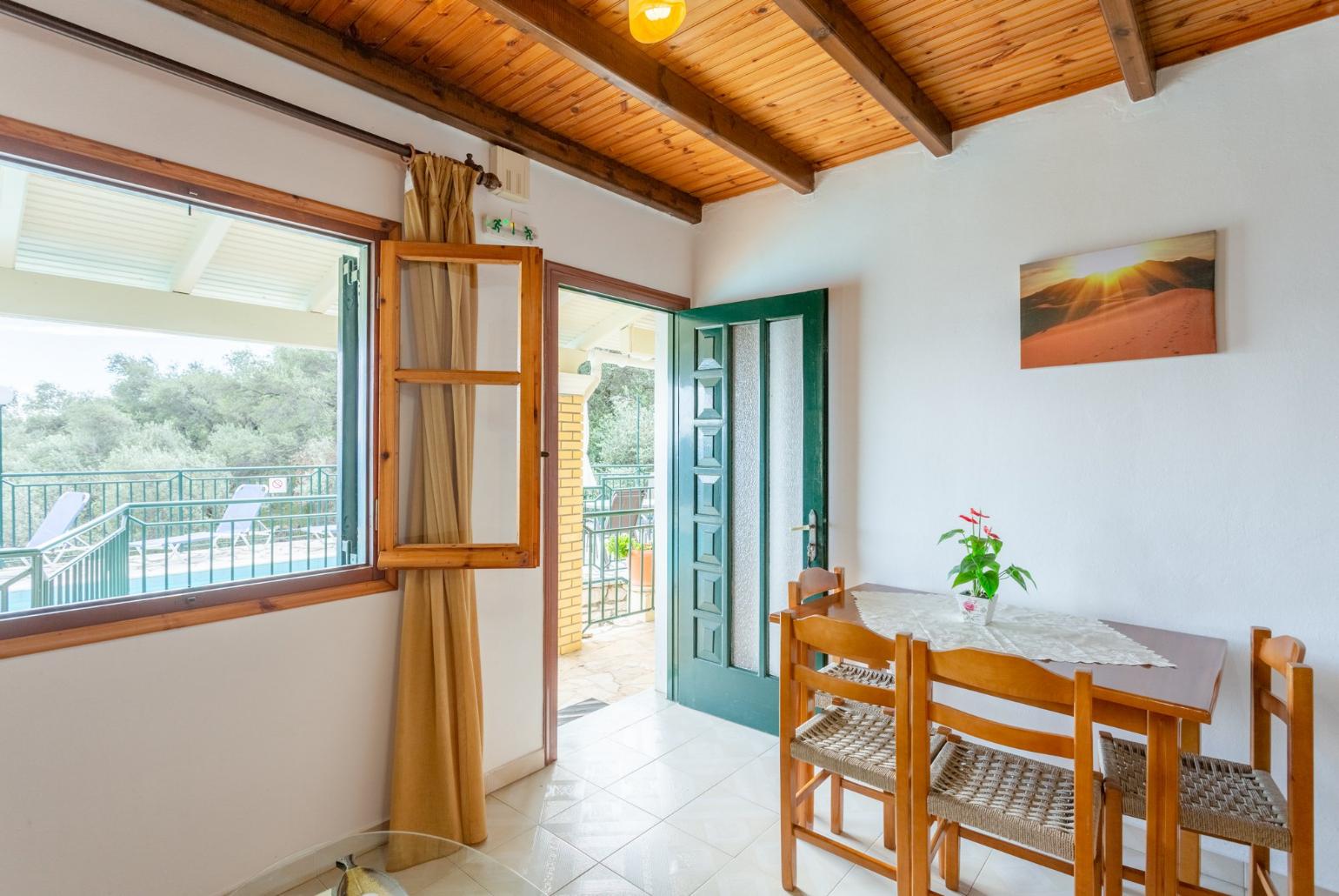 Living room with sofa, dining area, kitchen, and terrace access