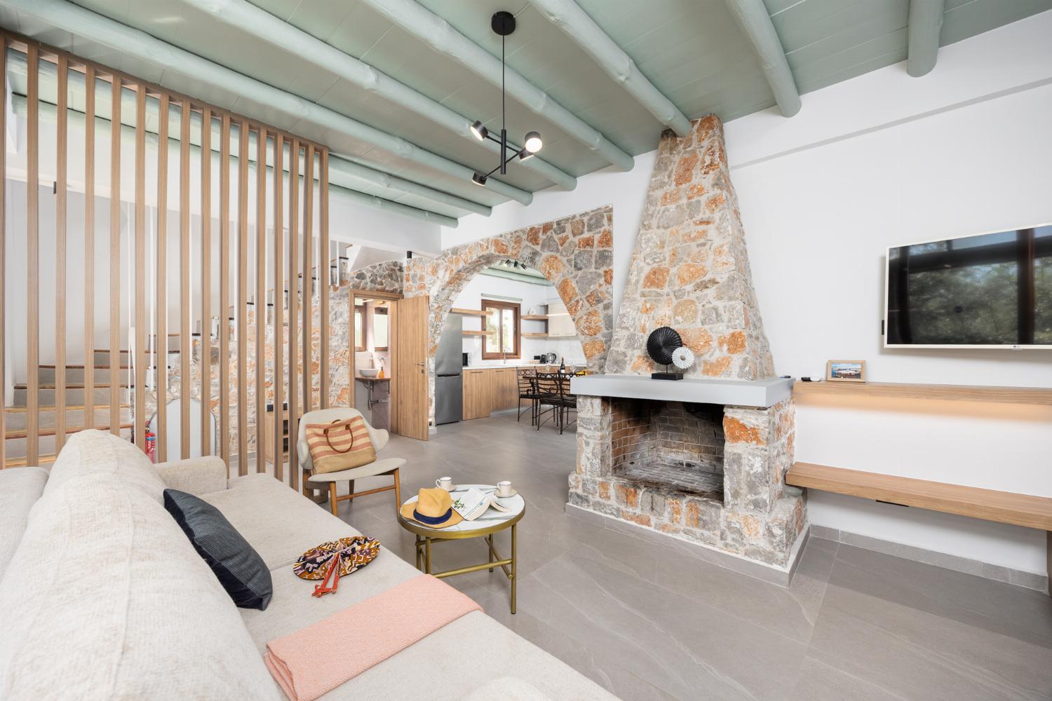 Open-plan living room with sofa, dining area, kitchen, indoor pool, ornamental fireplace, A/C, WiFi internet, and satellite TV