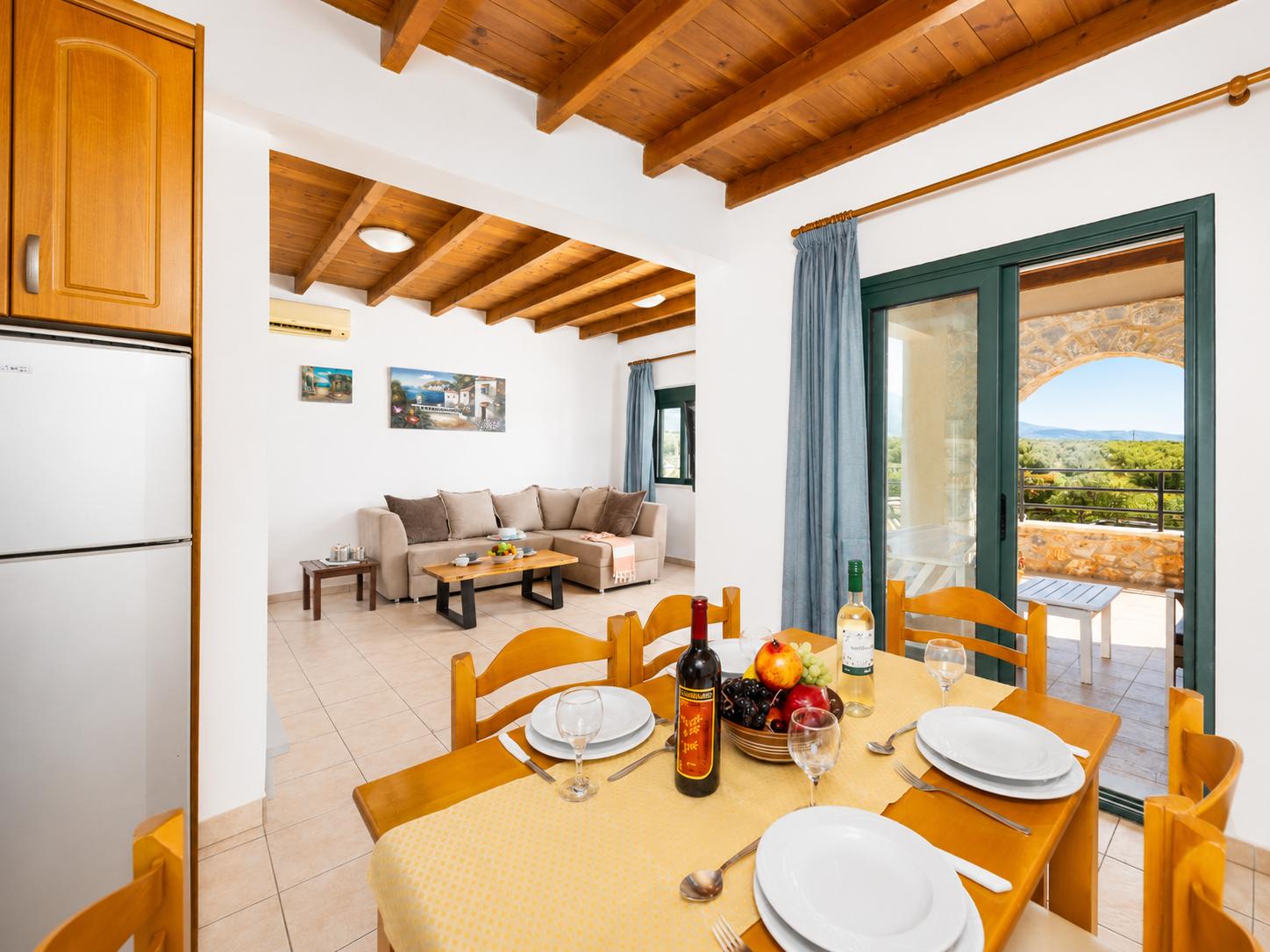 Open-plan living room with sofa, dining area, kitchen, A/C, WiFi internet, and satellite TV