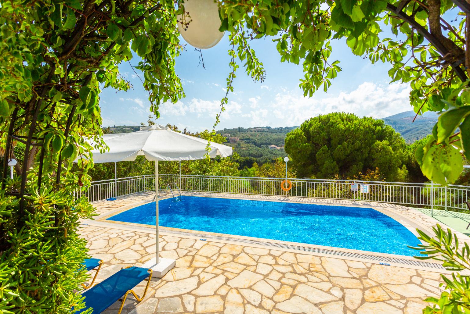 Shared pool, terrace, and garden with countryside views