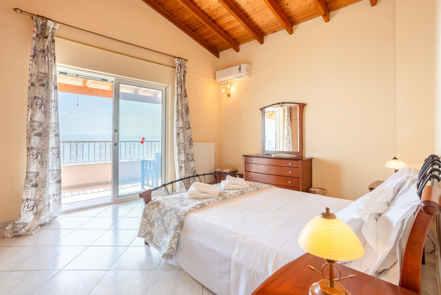 Double bedroom with en suite bathroom, A/C, and upper terrace access with panoramic sea views