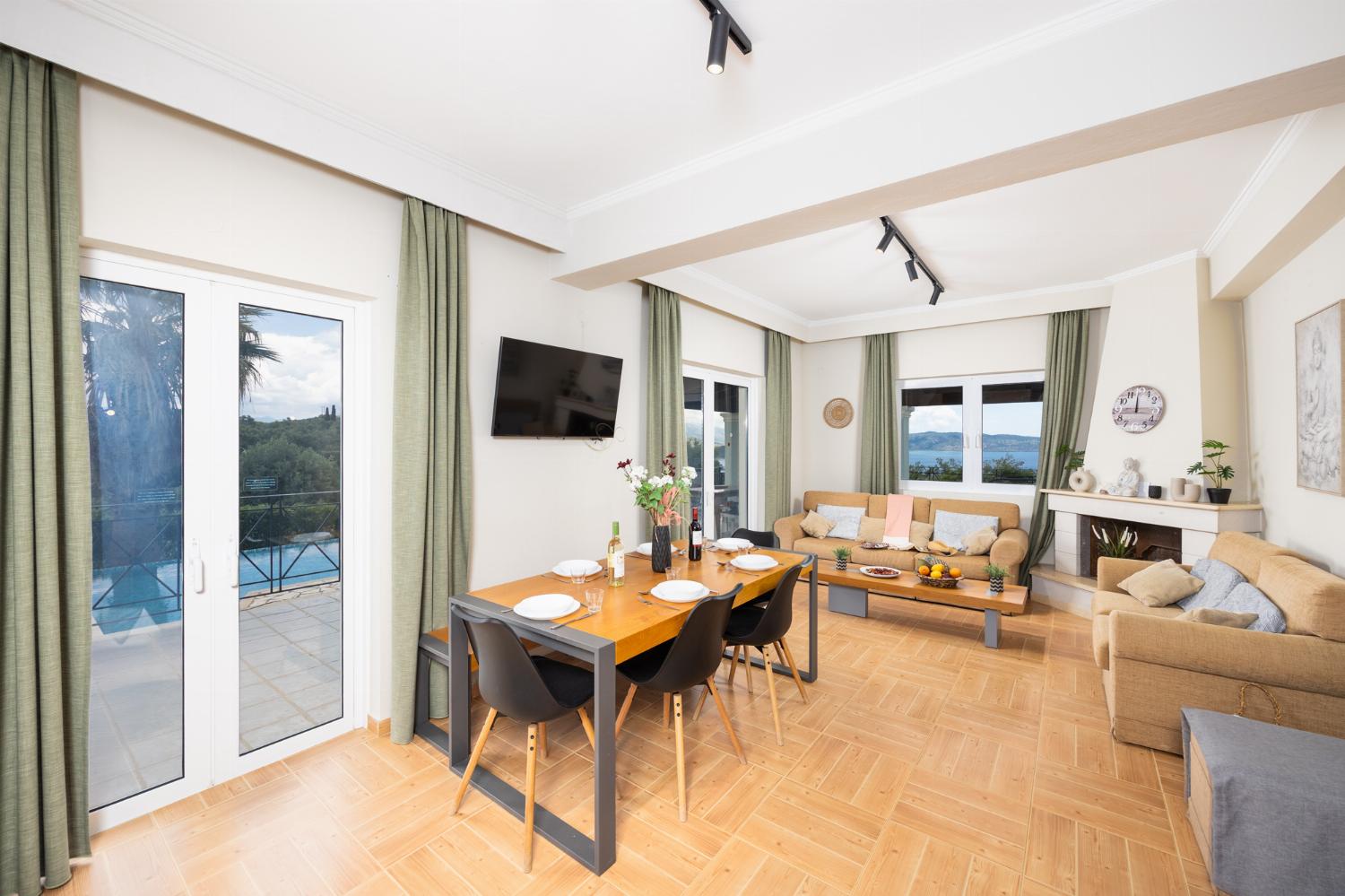 Open-plan living room with sofas, dining area, kitchen, ornamental fireplace, WiFi internet, and satellite TV