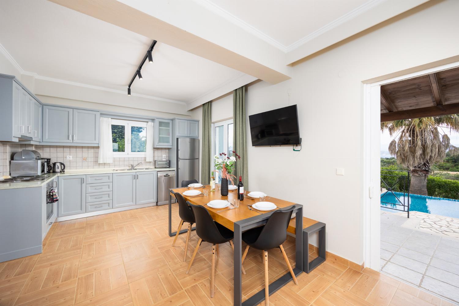 Open-plan living room with sofas, dining area, kitchen, ornamental fireplace, WiFi internet, and satellite TV
