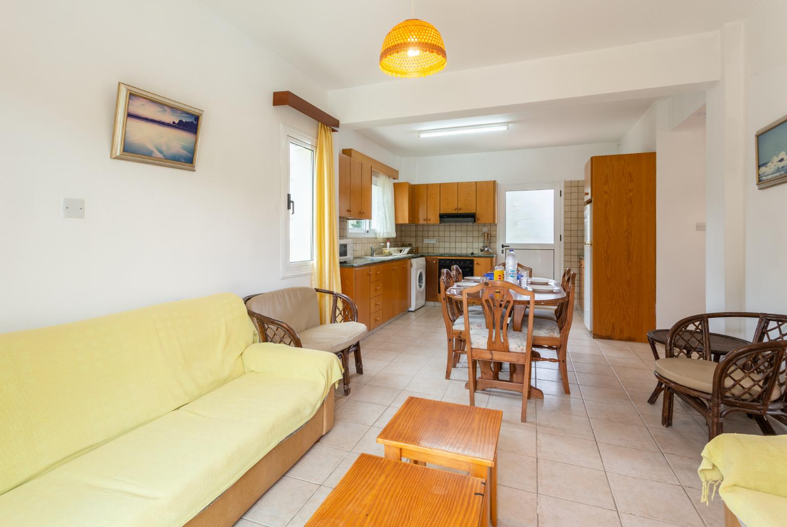 Open-plan living room with sofas, dining area, kitchen, ornamental fireplace, WiFi internet, and satellite TV