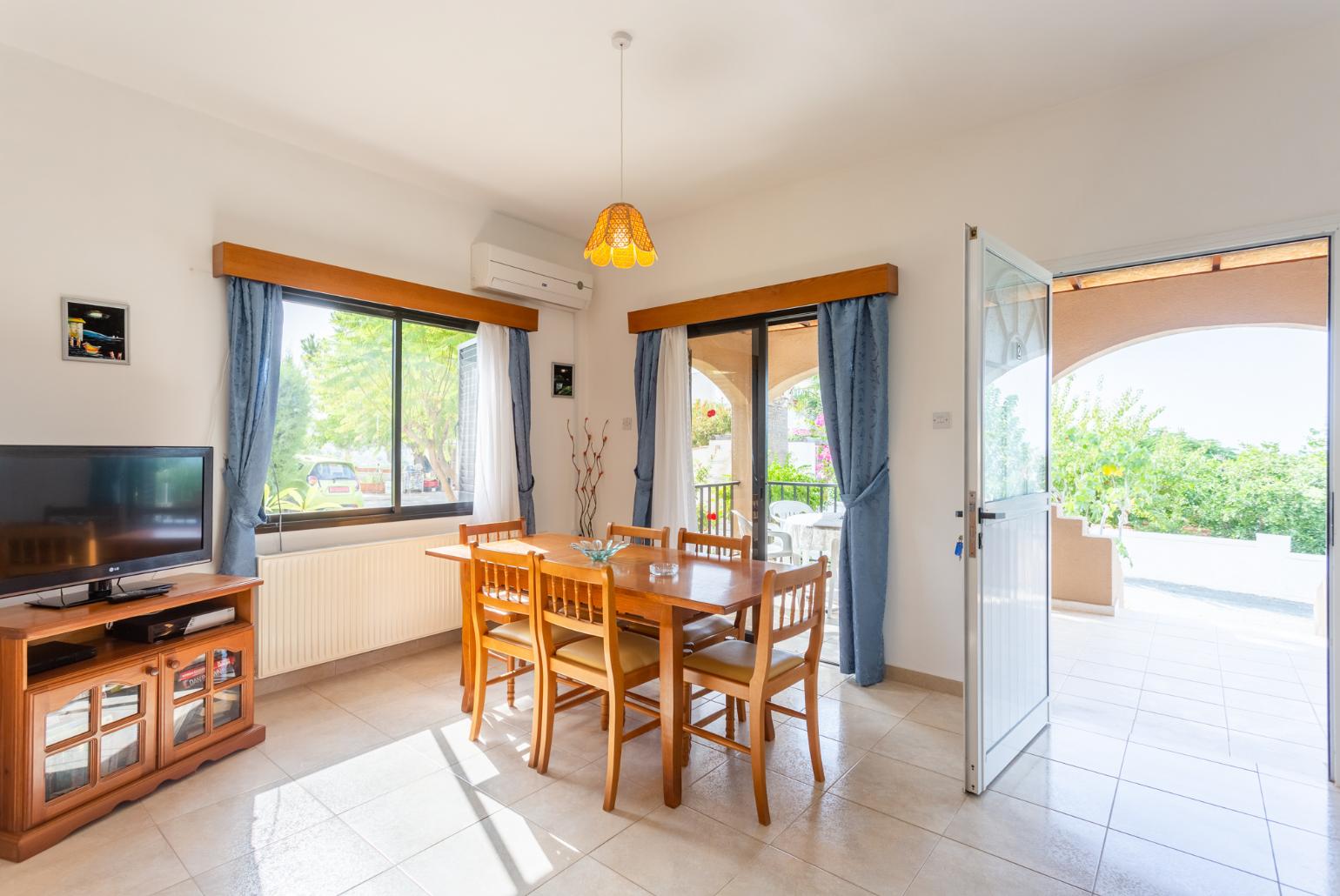 Open-plan living room with sofas, dining area, kitchen, ornamental fireplace, A/C, WiFi internet, satellite TV, DVD player, and terrace access