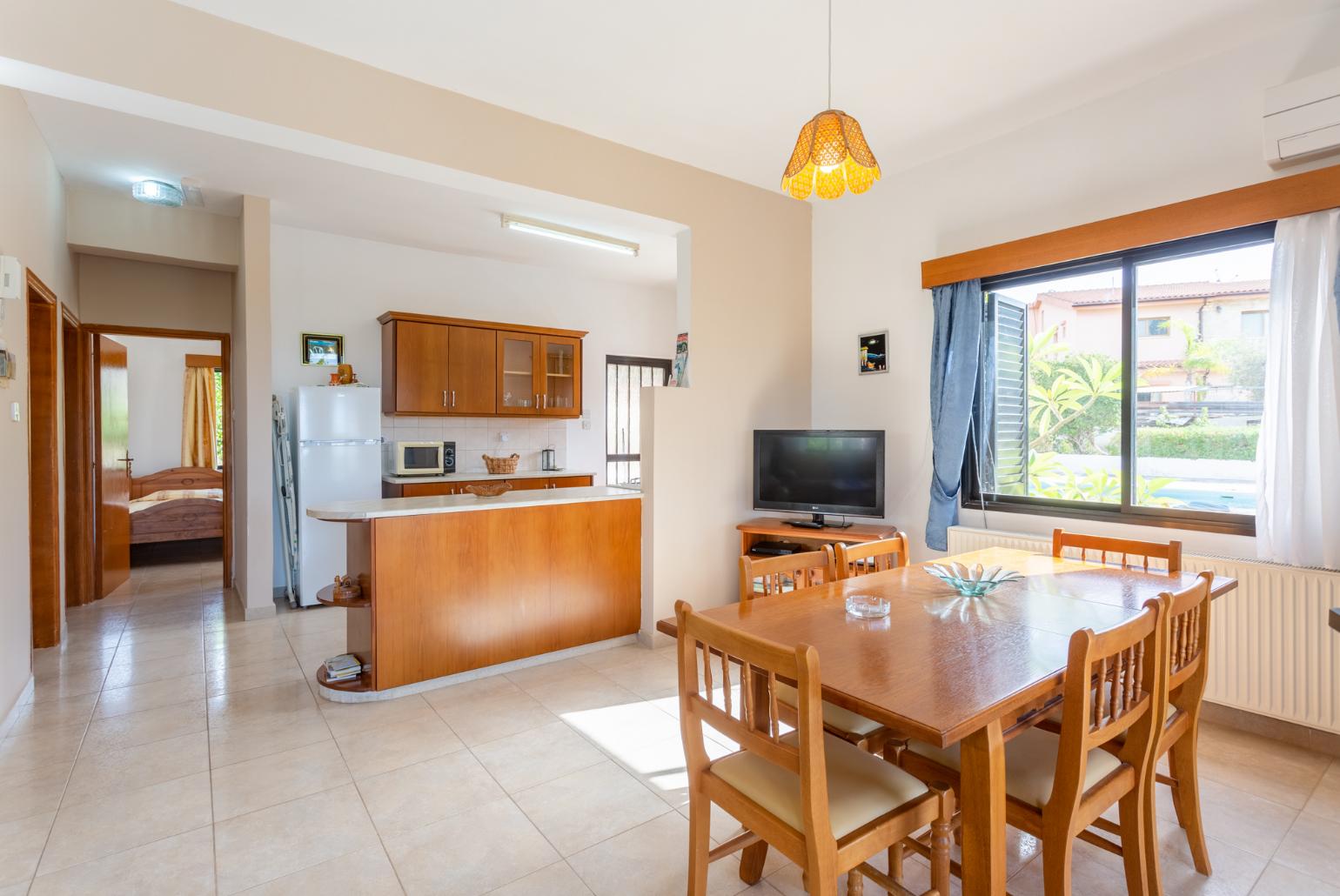 Open-plan living room with sofas, dining area, kitchen, ornamental fireplace, A/C, WiFi internet, satellite TV, DVD player, and terrace access