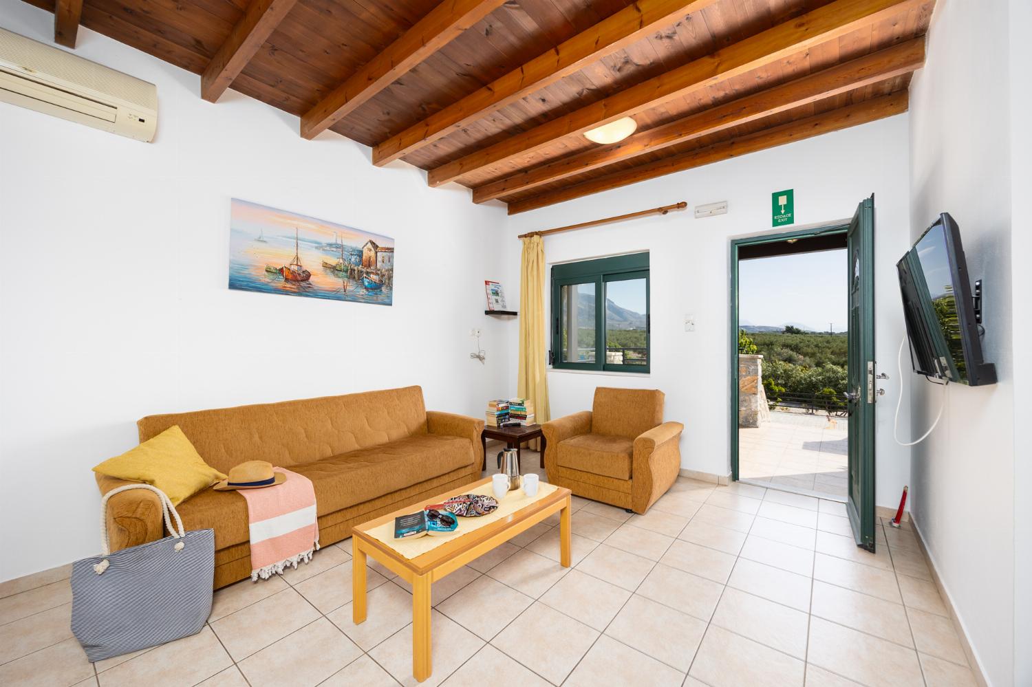 Upper unit: open-plan living room with sofa, dining area, kitchen, A/C, WiFi internet, and satellite TV