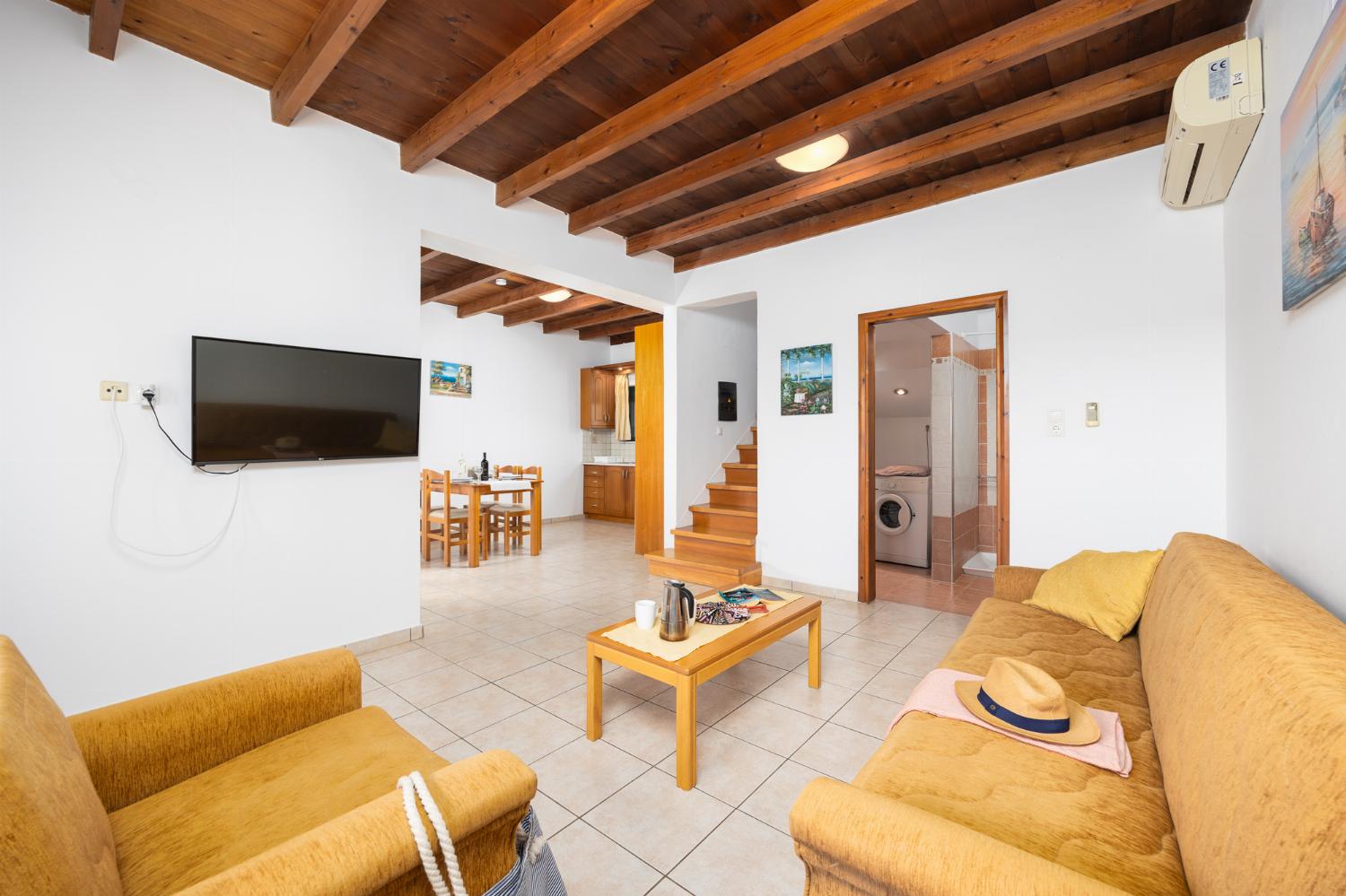 Upper unit: open-plan living room with sofa, dining area, kitchen, A/C, WiFi internet, and satellite TV