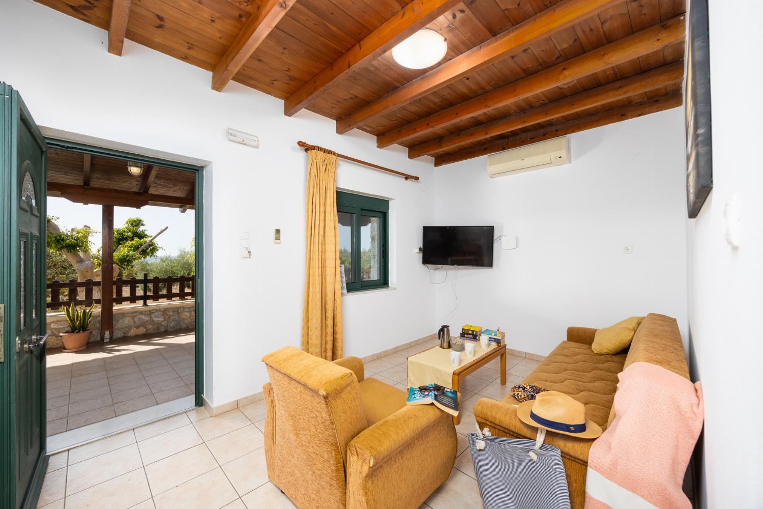 Lower unit: open-plan living room with sofa, dining area, kitchen, A/C, WiFi internet, and satellite TV