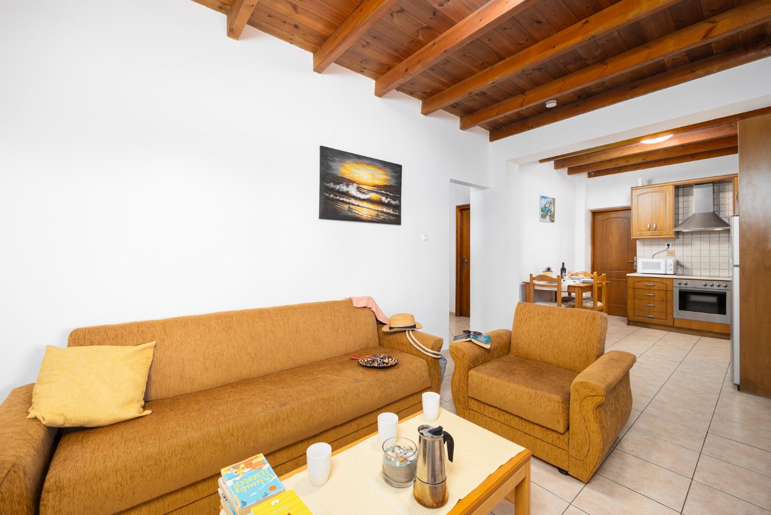 Lower unit: open-plan living room with sofa, dining area, kitchen, A/C, WiFi internet, and satellite TV