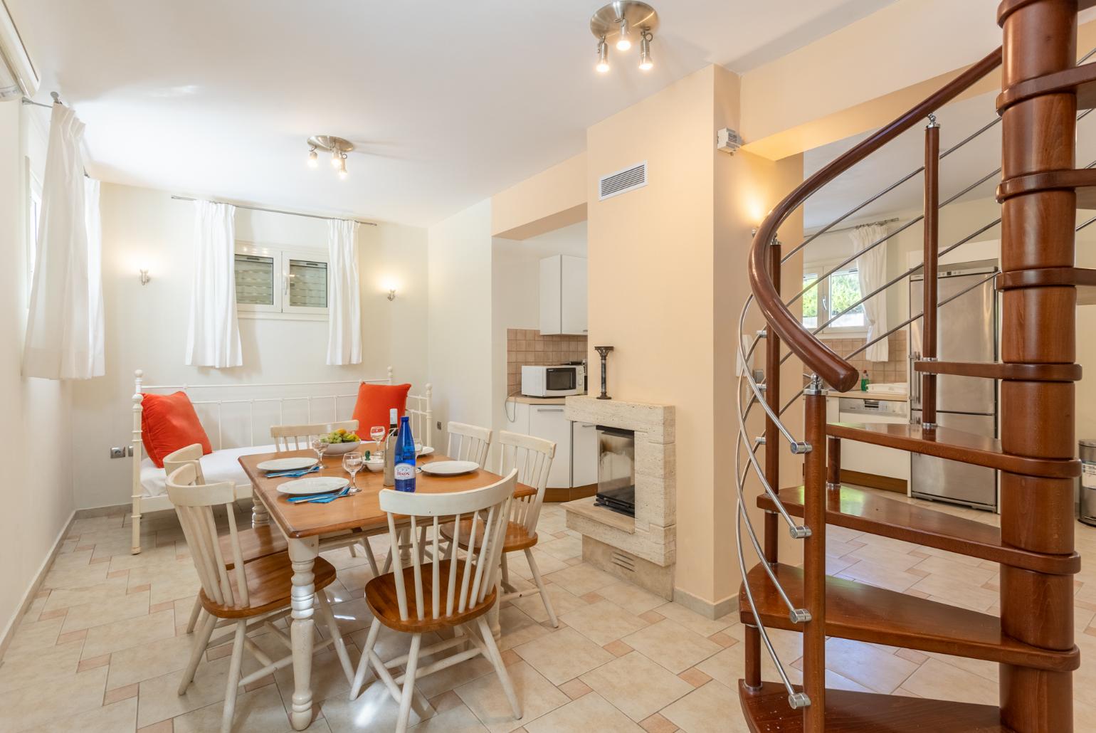 Living area on ground floor with sofa, dining area, kitchen, ornamental fireplace, A/C, and WiFi internet