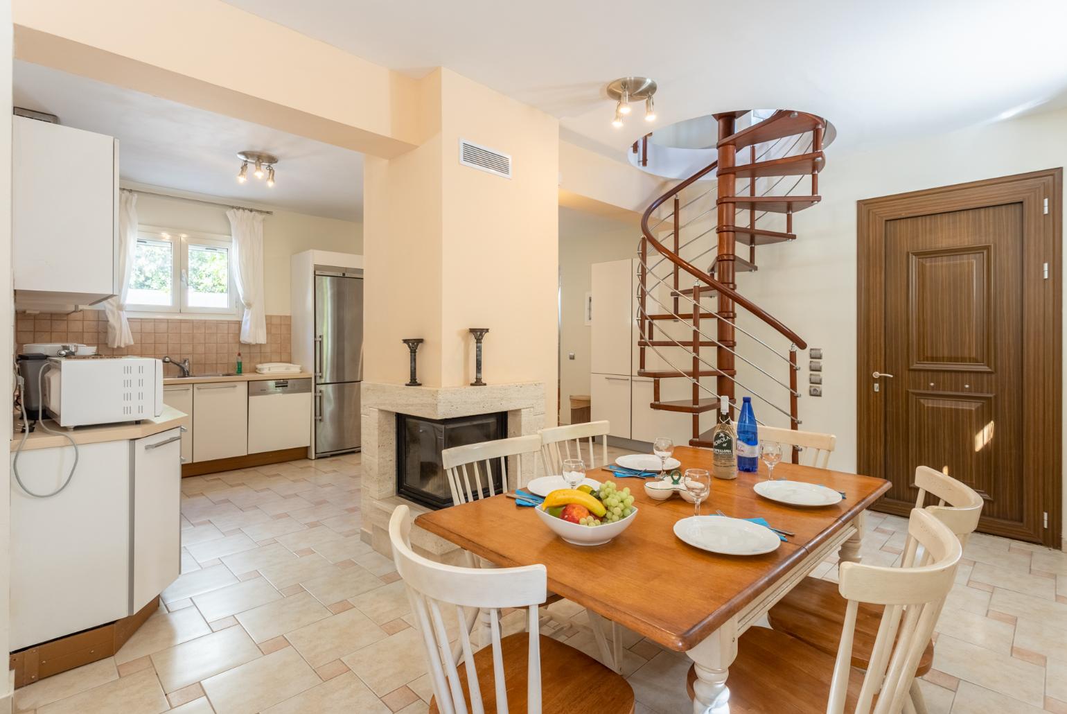 Living area on ground floor with sofa, dining area, kitchen, ornamental fireplace, A/C, and WiFi internet