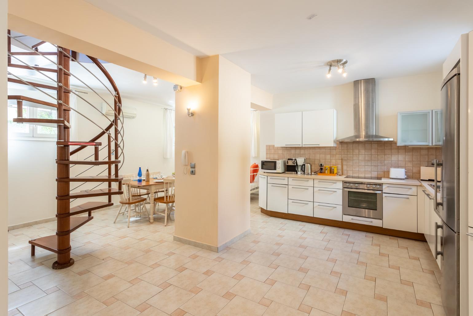 Living area on ground floor with sofa, dining area, kitchen, ornamental fireplace, A/C, and WiFi internet