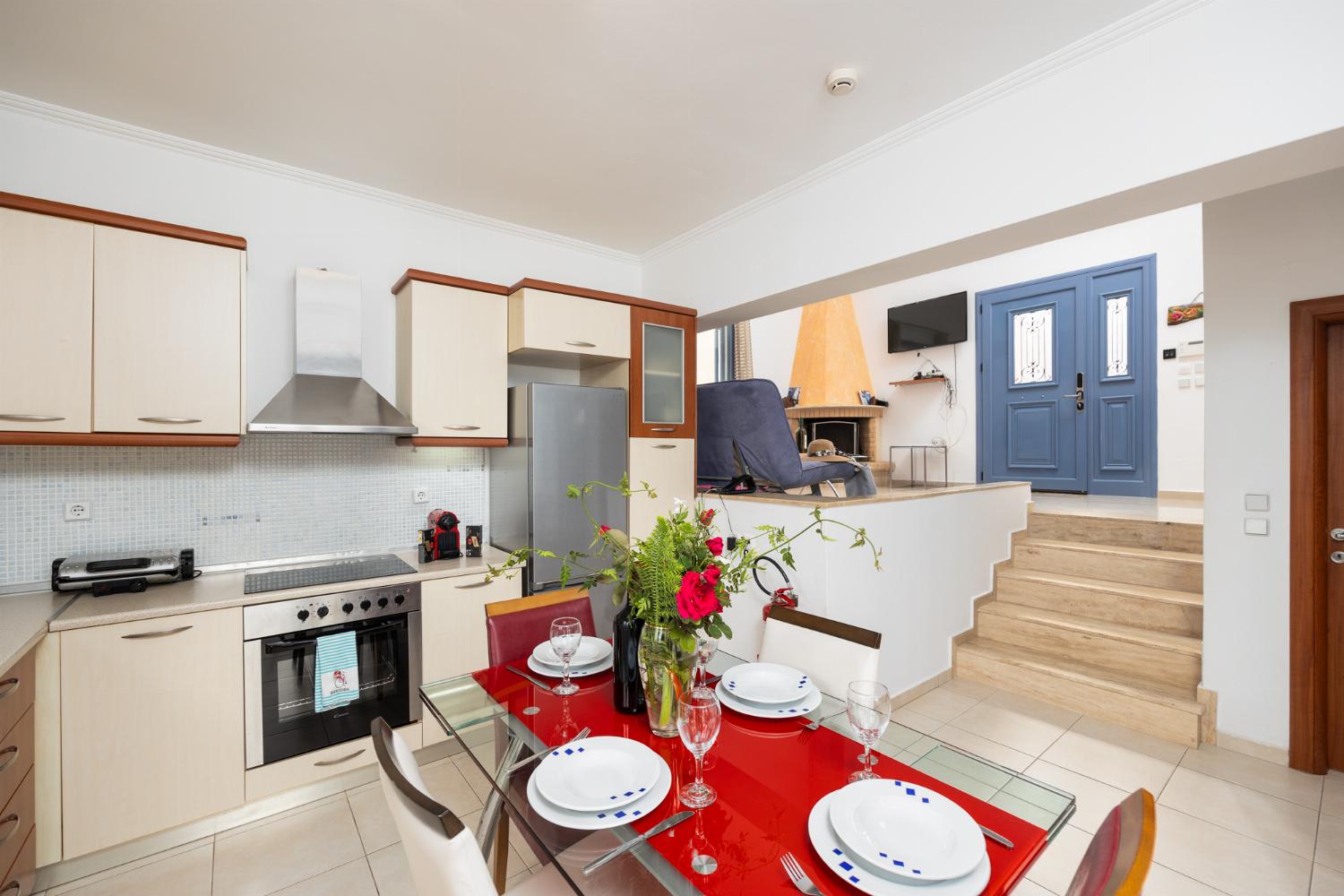Open-plan living room with sofa, dining area, kitchen, ornamental fireplace, A/C, WiFi internet, and satellite TV