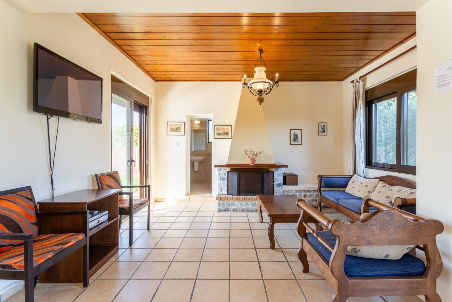 Living room with sofa, dining area, ornamental fireplace, WiFi internet, satellite TV, DVD player, and pool terrace access