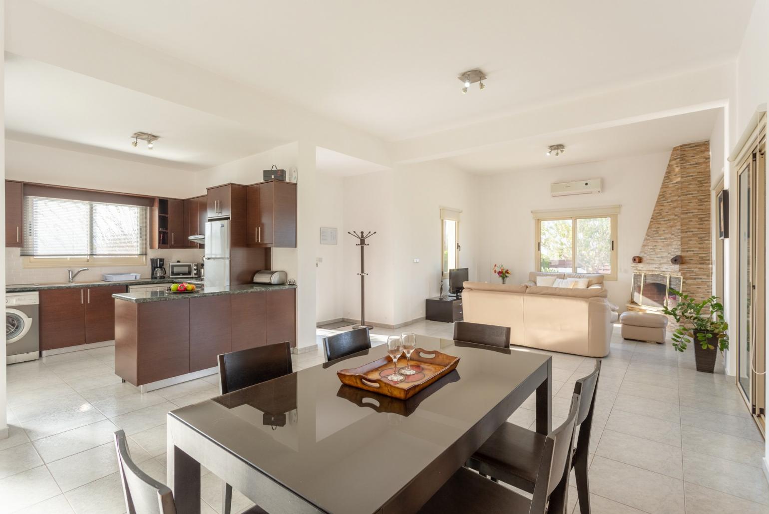 Open-plan living room with sofas, dining area, kitchen, ornamental fireplace, A/C, WiFi internet, satellite TV, DVD player, and terrace access