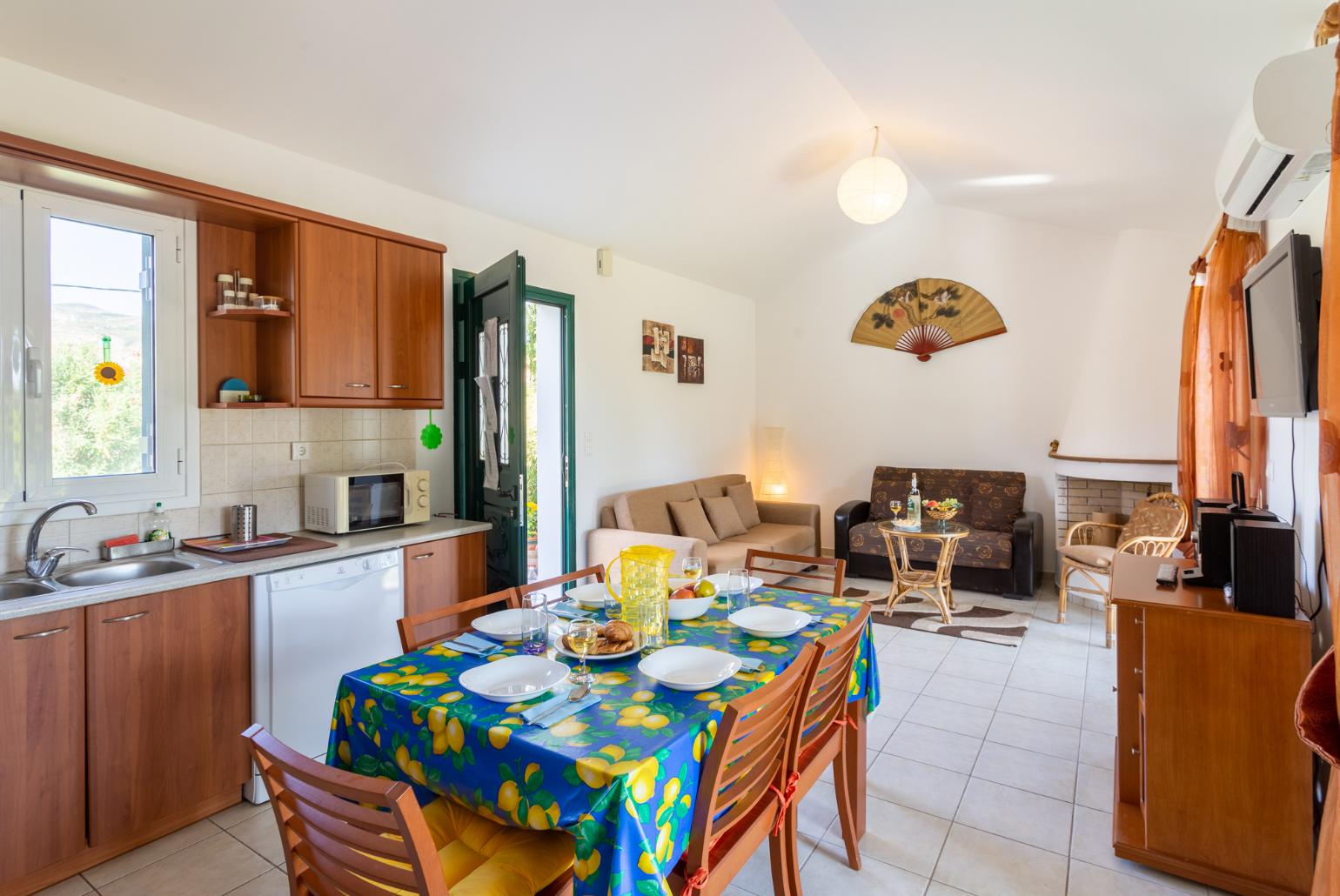 Open-plan living room with sofas, dining area, kitchen, ornamental fireplace, A/C, WiFi internet, satellite TV, and terrace access