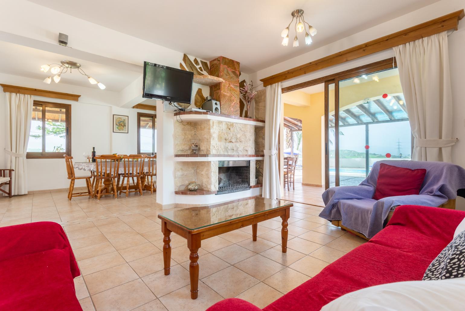 Open-plan living room with sofas, dining area, kitchen, ornamental fireplace, WiFi internet, and satellite TV