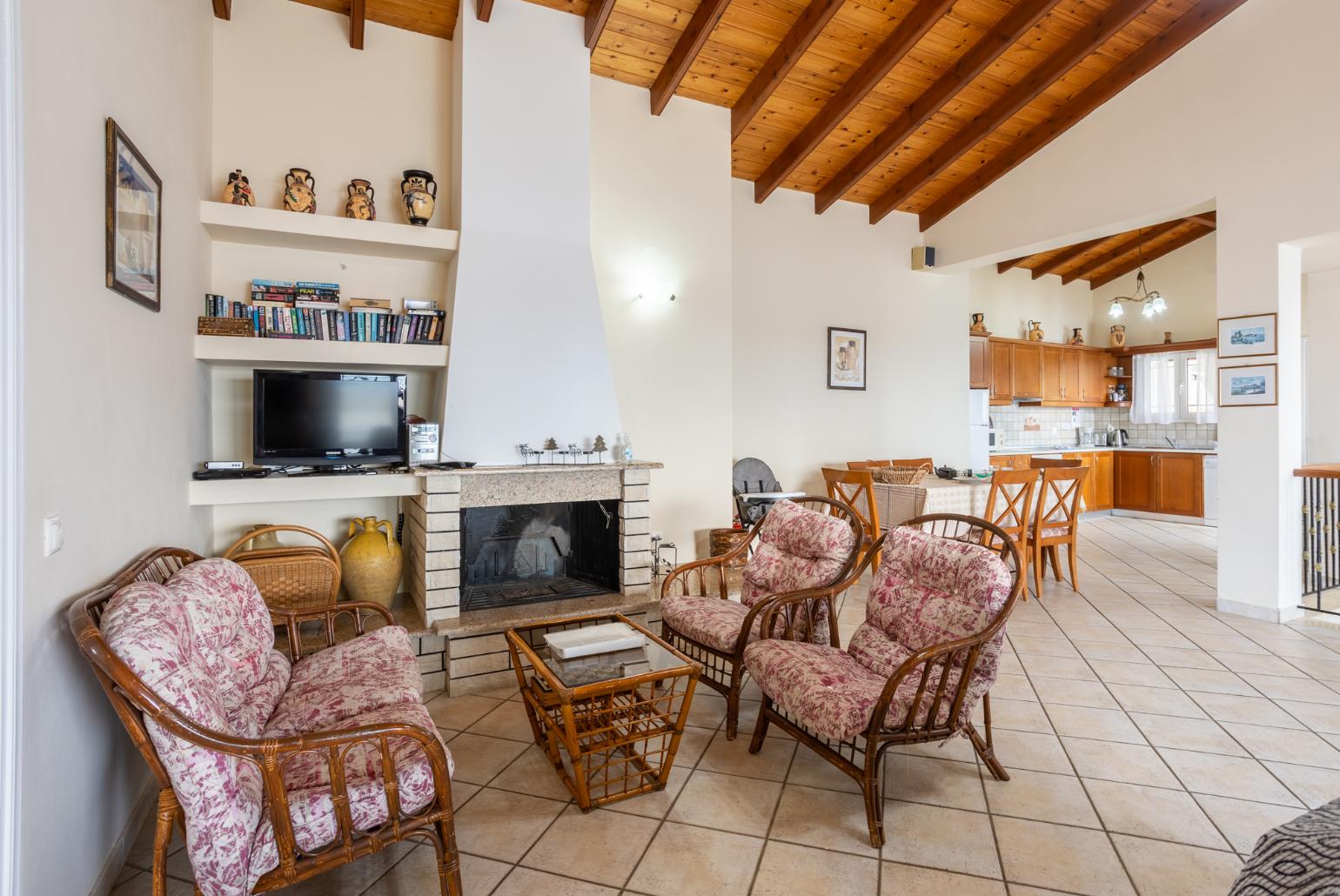 Open-plan living room with sofas, dining area, kitchen, ornamental fireplace, WiFi internet, satellite TV, and sea views