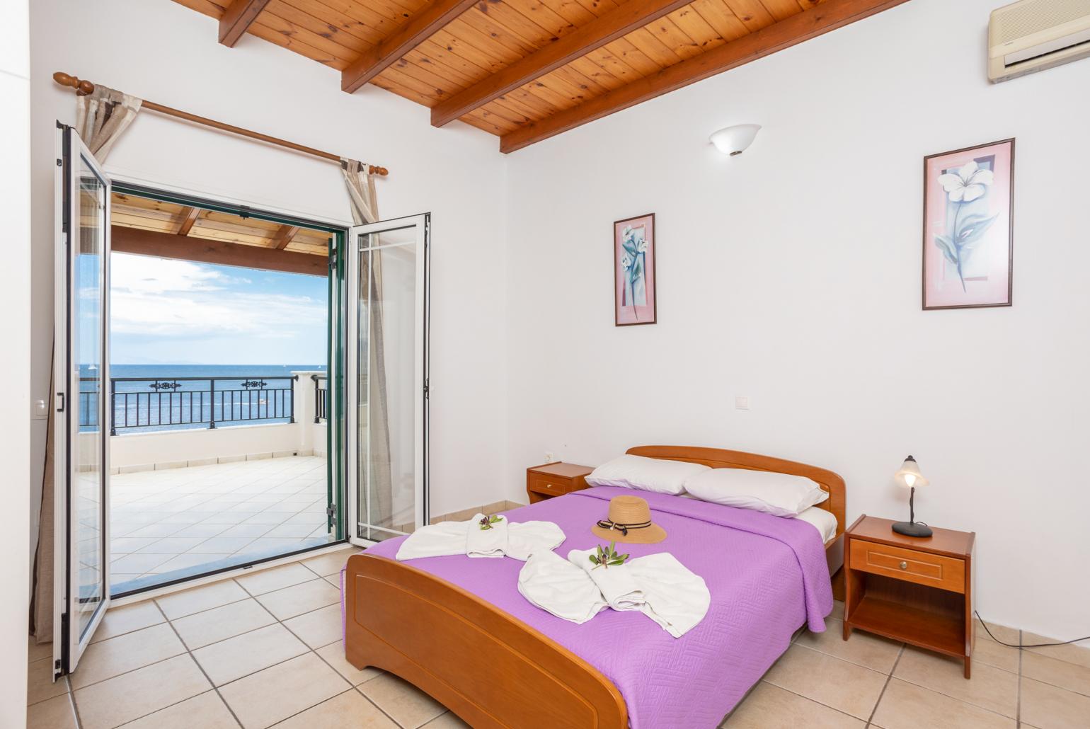 Double bedroom with en suite bathroom, A/C, terrace access, and sea views