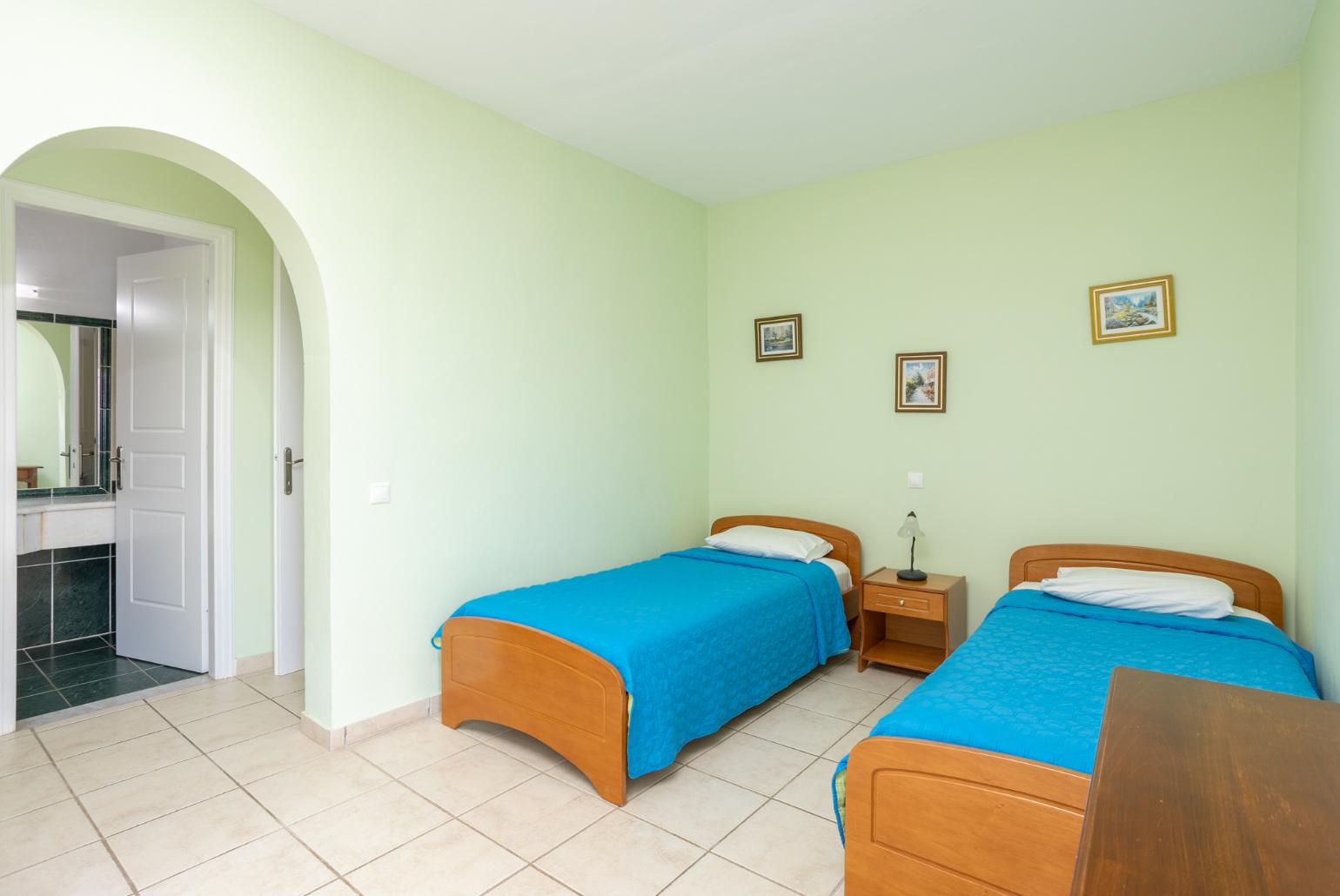 Twin bedroom with en suite bathroom, A/C, terrace access, and sea views