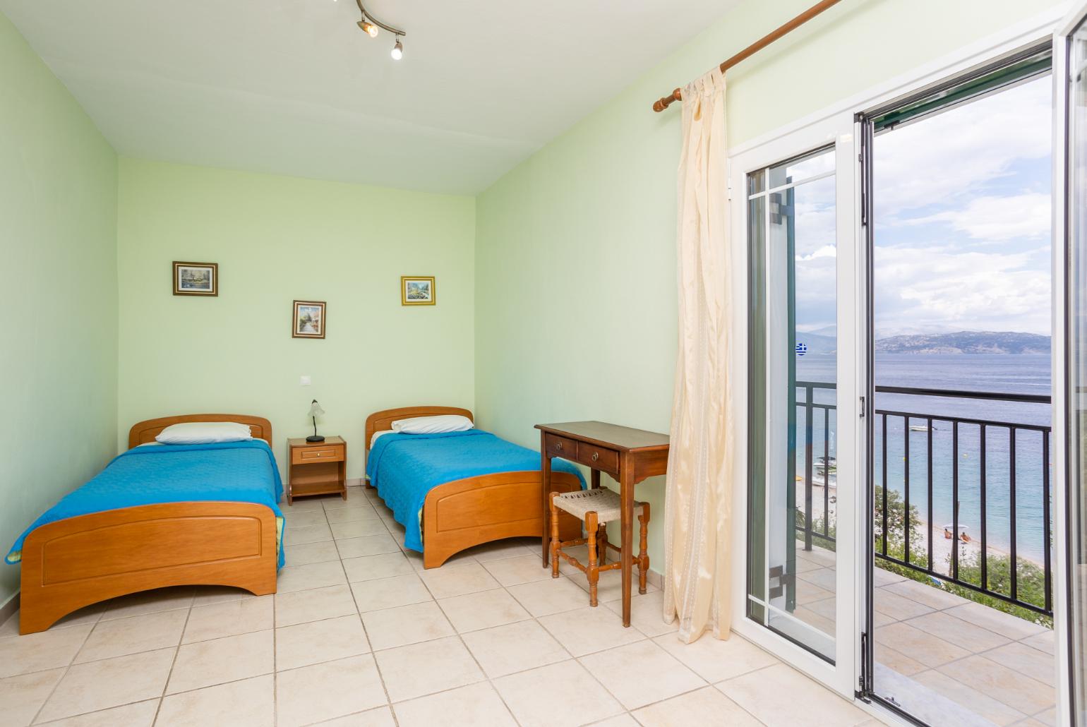 Twin bedroom with en suite bathroom, A/C, terrace access, and sea views