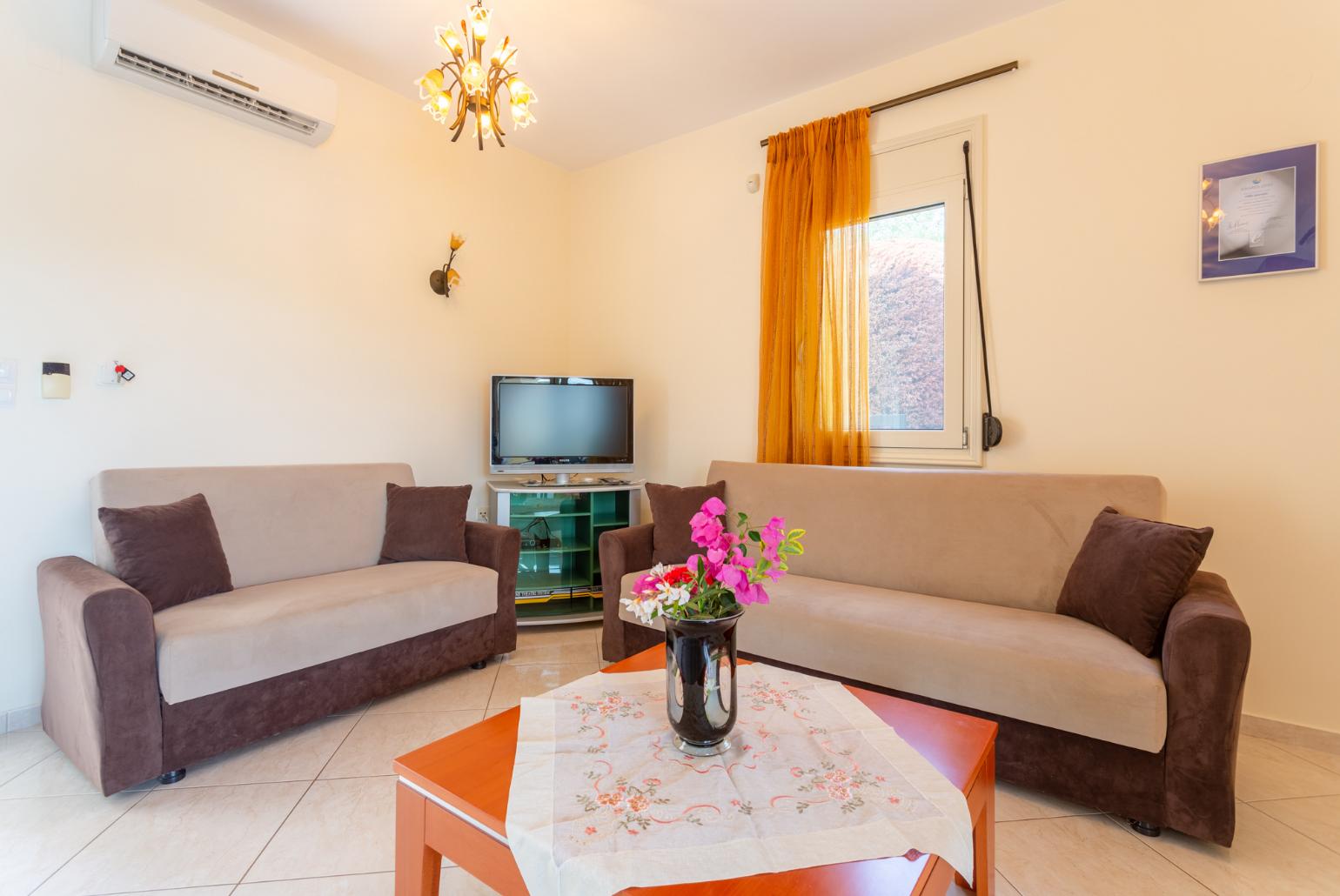 Open-plan living room with sofas, dining area, kitchen, A/C, WiFi internet, satellite TV, DVD player, and terrace access