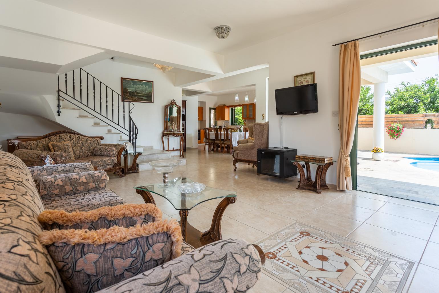 Open-plan living room with sofas, dining area, kitchen, ornamental fireplace, A/C, WiFi internet, satellite TV, and terrace access