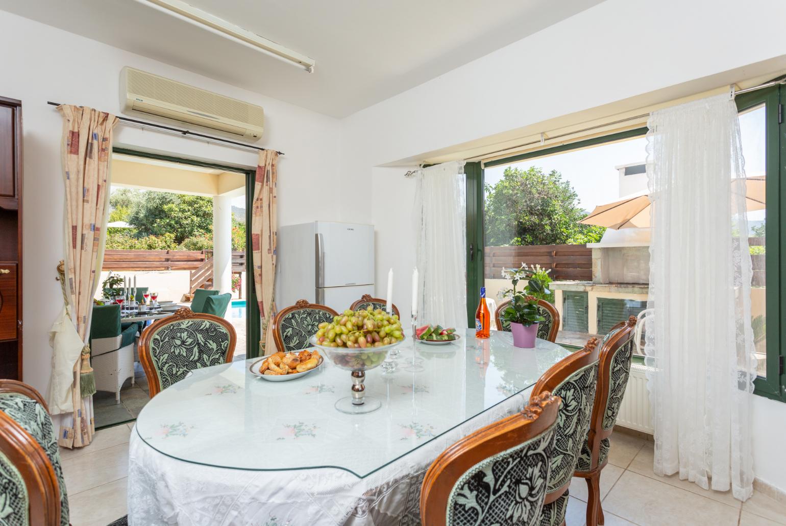 Open-plan living room with sofas, dining area, kitchen, ornamental fireplace, A/C, WiFi internet, satellite TV, and terrace access