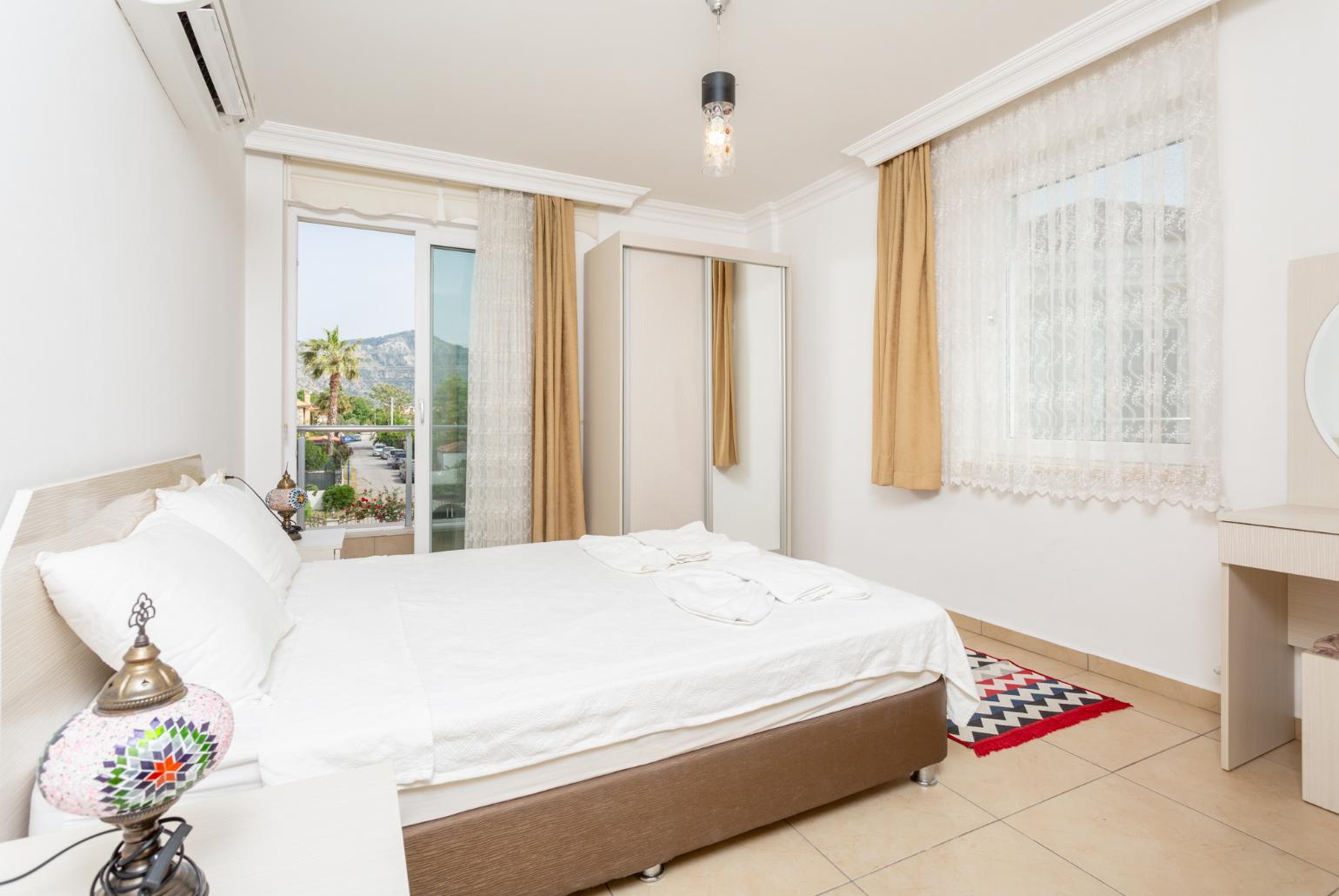 Double bedroom with en suite bathroom, A/C, and balcony access