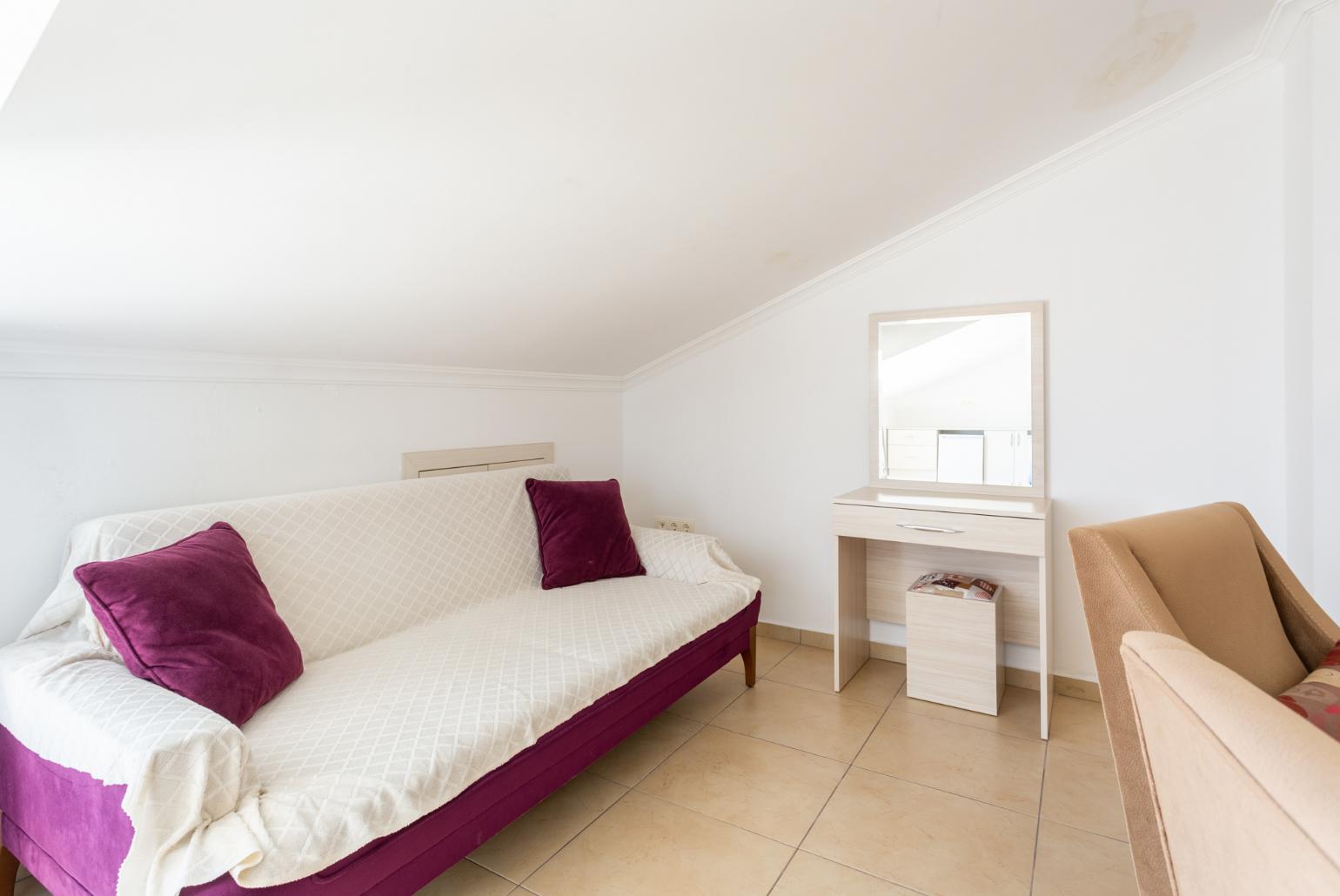 Double bedroom with en suite bathroom, A/C, seating, ornamental fireplace, and balcony access