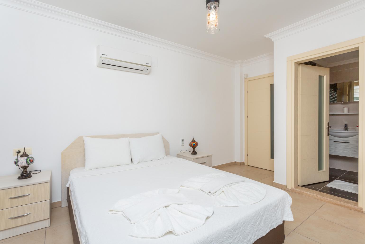 Double bedroom with en suite bathroom, A/C, and balcony access