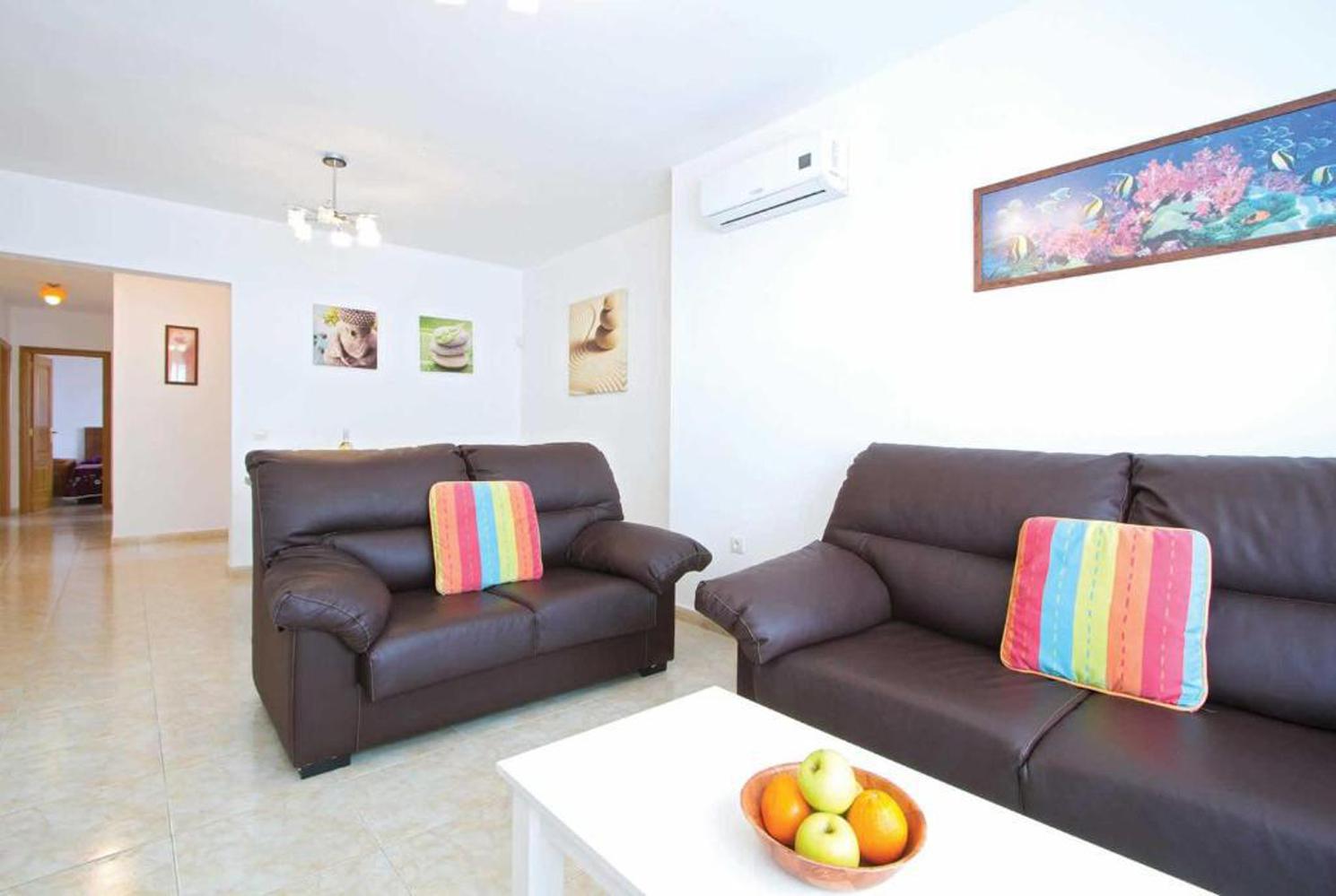 Open plan living room with comfortable sofas, WiFi, TV, A/C
