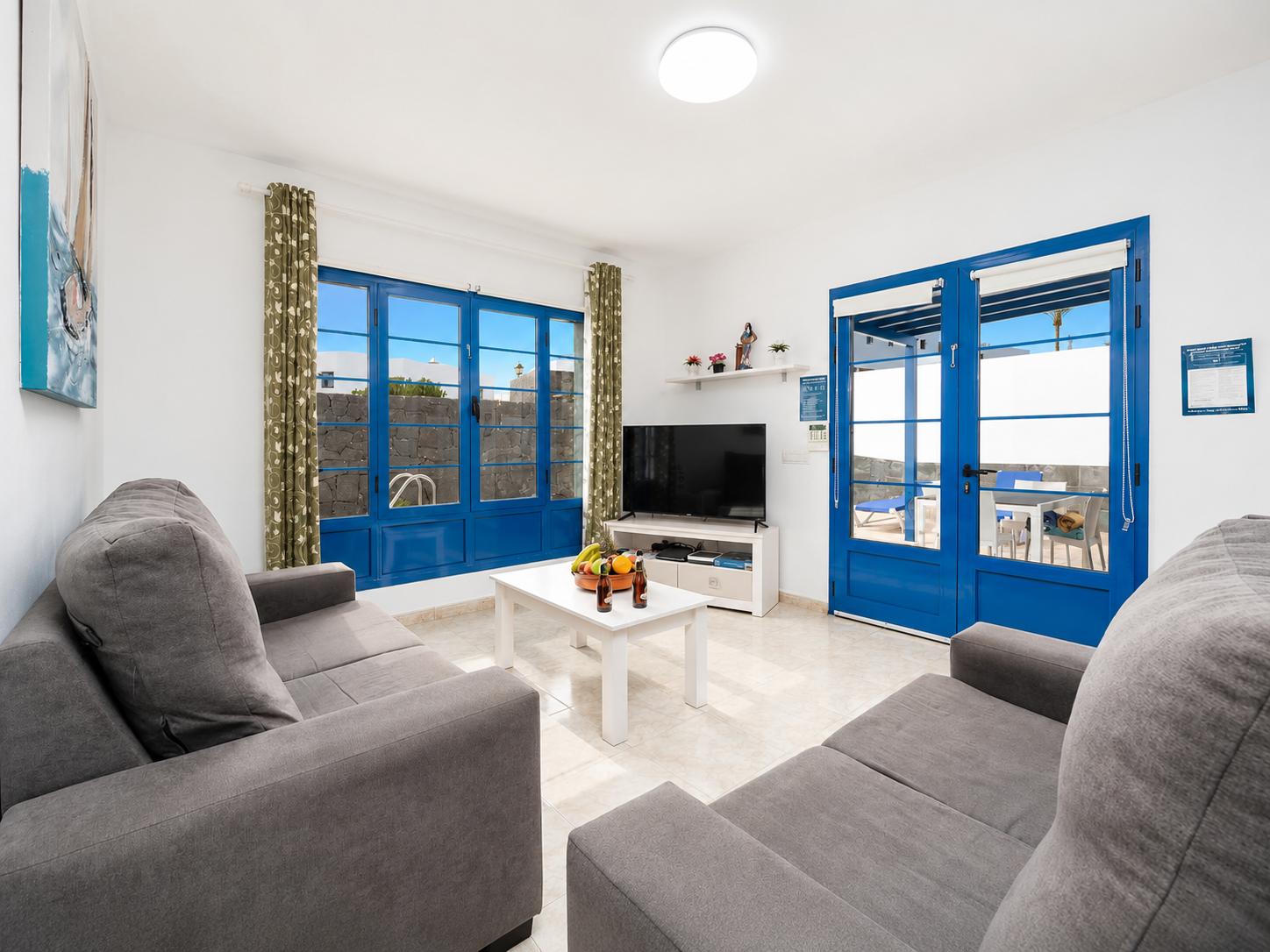 Living room with sofas, dining area, A/C, WiFi internet, and satellite TV
