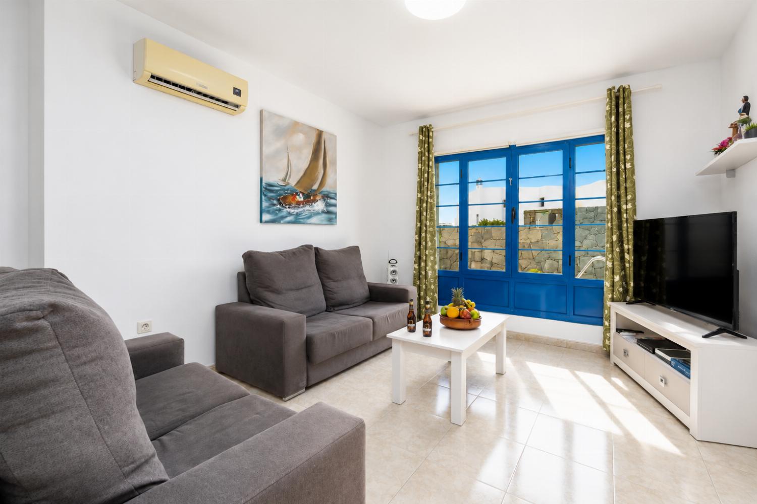 Living room with sofas, dining area, A/C, WiFi internet, and satellite TV