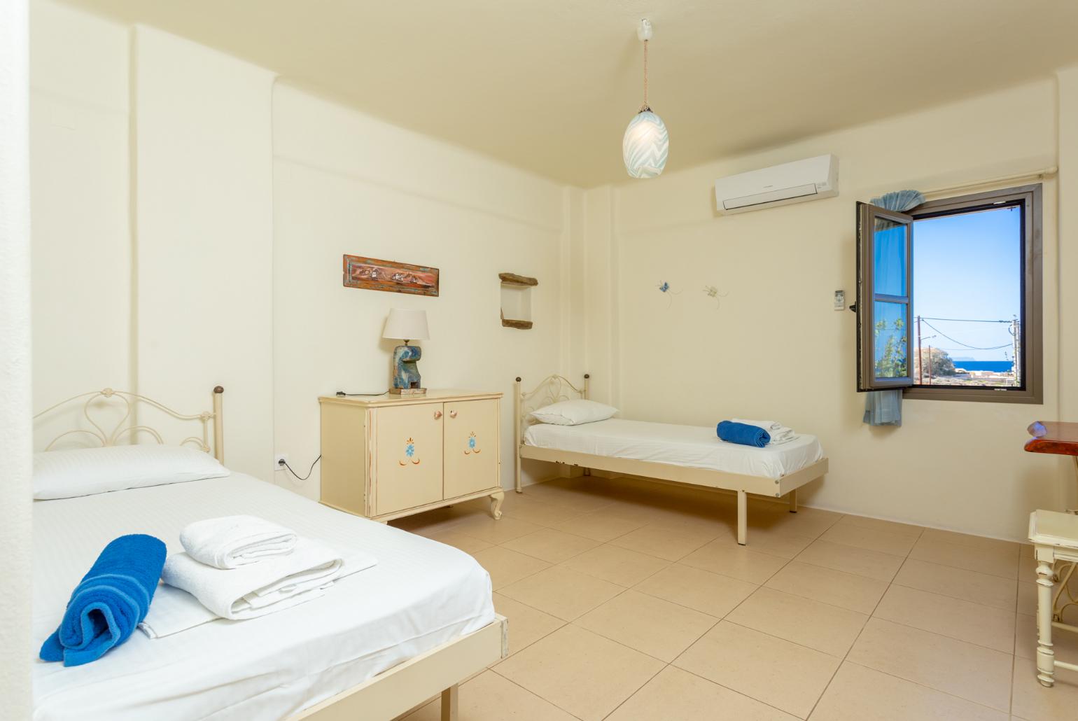 Twin bedroom with en suite bathroom, A/C, and balcony with sea views