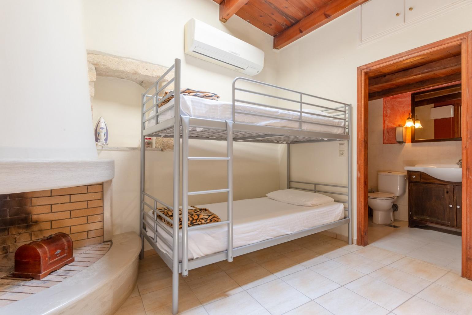 Living area with bunkbed, A/C, and TV